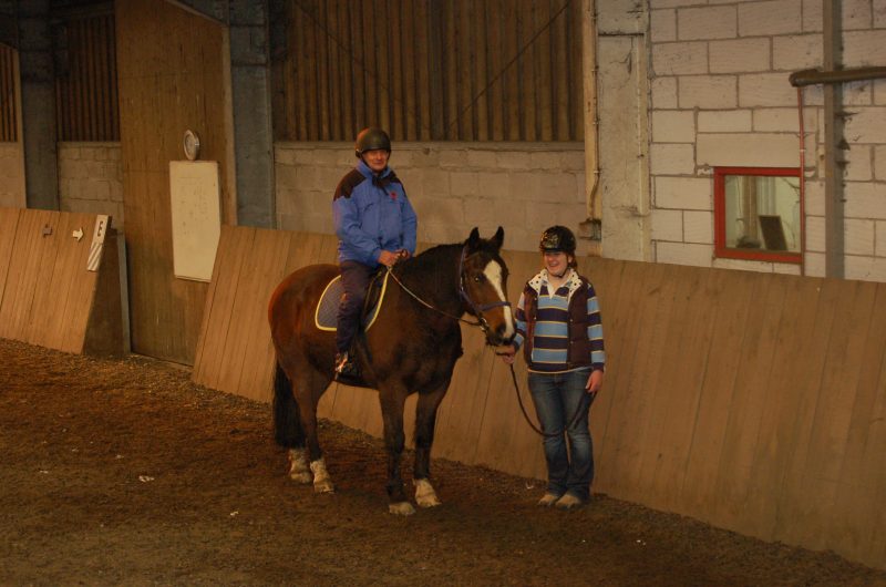 Spud and volunteer helper in riding arena