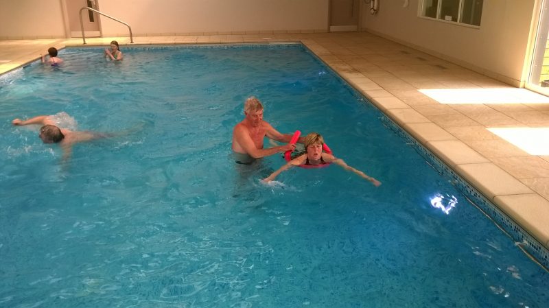 Spud helping Sue, Graham swimming and Aileen and Jean near the steps