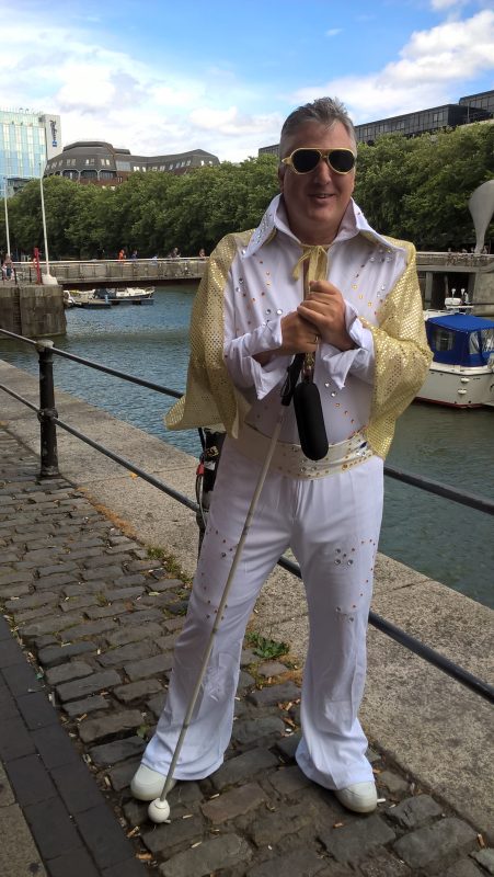 JOHN IN HIS ELVIS OUTFIT, BRISTOL  WATERFRONT IN THE BACKGROUND