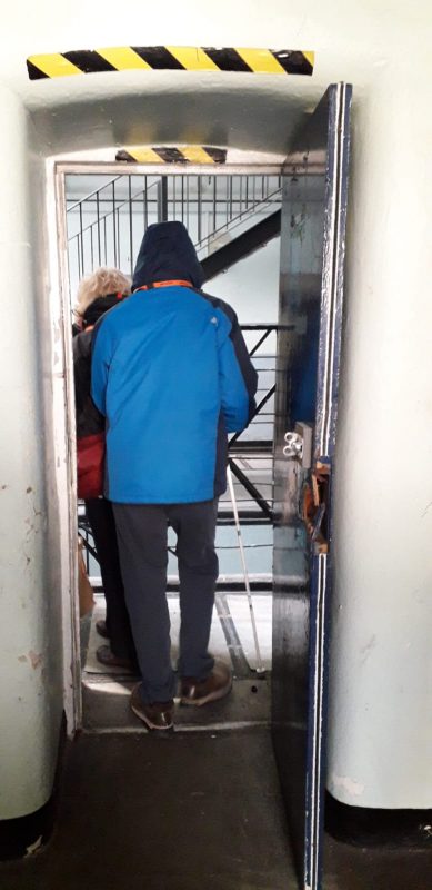 AILEEN &amp; JAMES LEAVING ONE OF THE CELLS FROM THE 1600S, CONTAINING A METAL BED, TOILET BOWL AND SINK.