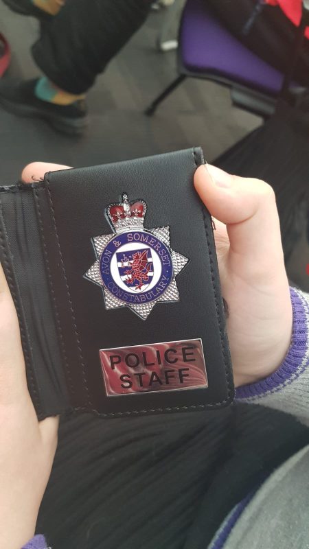 SAM HOLDING THE OFFICERS BADGE